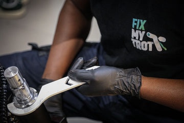 technicien qui répare une potence avec une clé